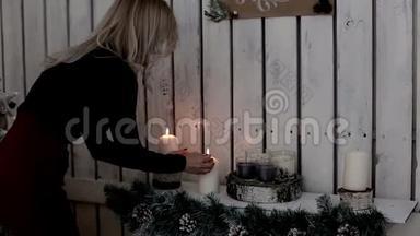 一位女士点燃蜡烛。 寒假的温暖和氛围.. 圣诞装饰。 圣诞节及新年快乐